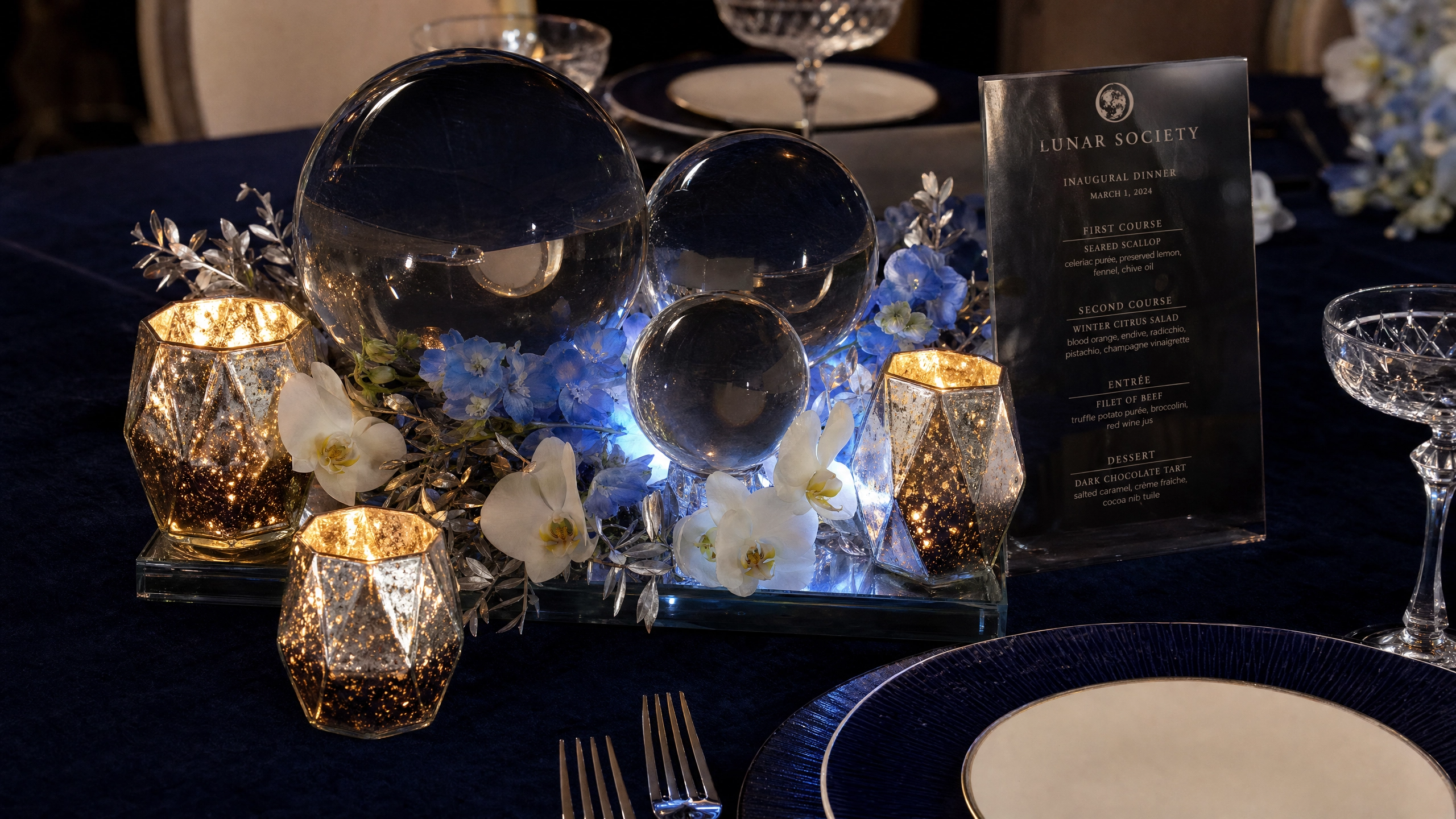 The Moon Pool Centerpiece features blue hydrangeas and white carnations to match the table aesthetic.